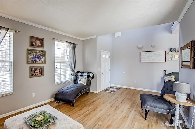 sitting room with light hardwood / wood-style flooring and ornamental molding