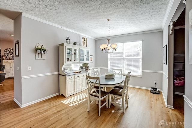 dining space with crown molding, a textured ceiling, an inviting chandelier, and light hardwood / wood-style flooring