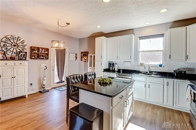 kitchen featuring sink, pendant lighting, and white cabinets