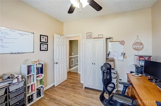 home office featuring a textured ceiling, ceiling fan, and light hardwood / wood-style flooring