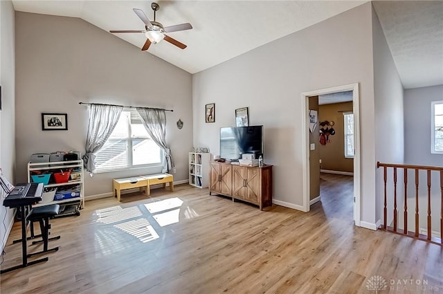 interior space with ceiling fan, high vaulted ceiling, plenty of natural light, and light hardwood / wood-style floors