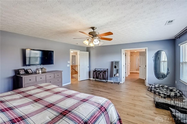 bedroom with ceiling fan, a textured ceiling, and light wood-type flooring