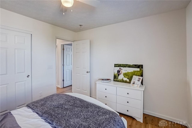 bedroom featuring ceiling fan, a textured ceiling, and light hardwood / wood-style flooring