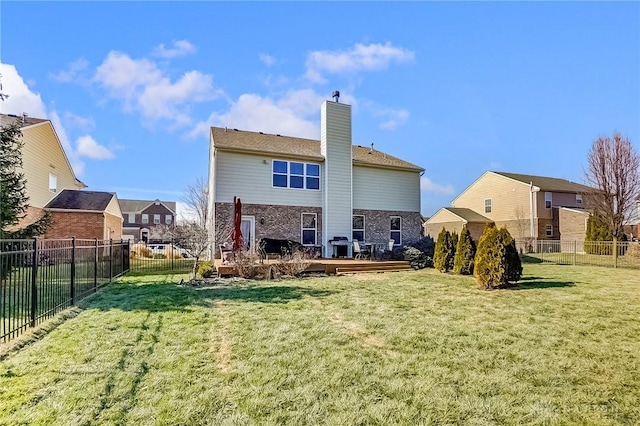 back of house with a wooden deck and a lawn