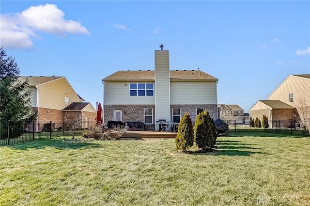 back of property featuring a wooden deck and a yard