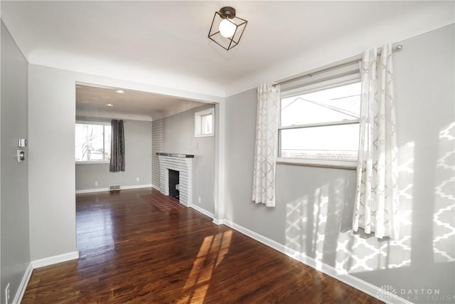 unfurnished living room featuring dark hardwood / wood-style floors and a fireplace