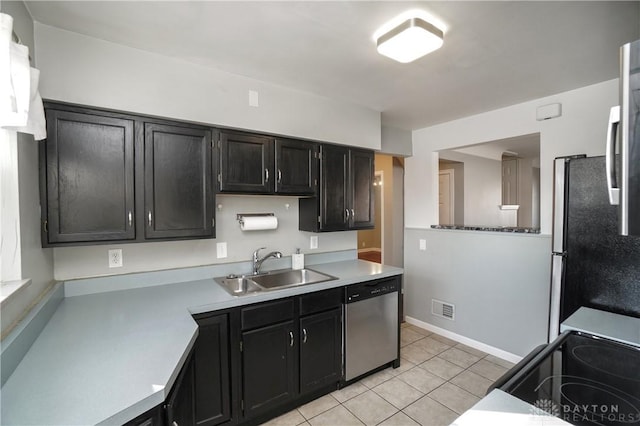 kitchen featuring light tile patterned flooring, appliances with stainless steel finishes, and sink