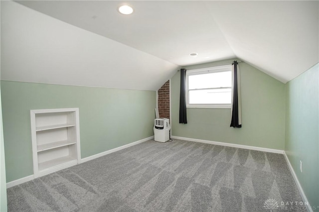 bonus room with carpet flooring, vaulted ceiling, and built in features