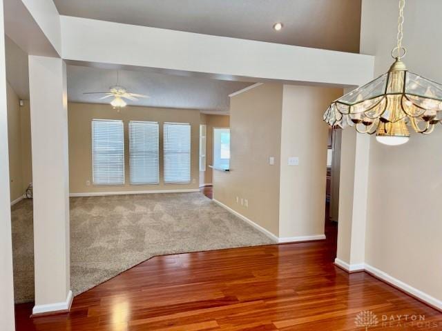 unfurnished room featuring ceiling fan with notable chandelier and hardwood / wood-style floors