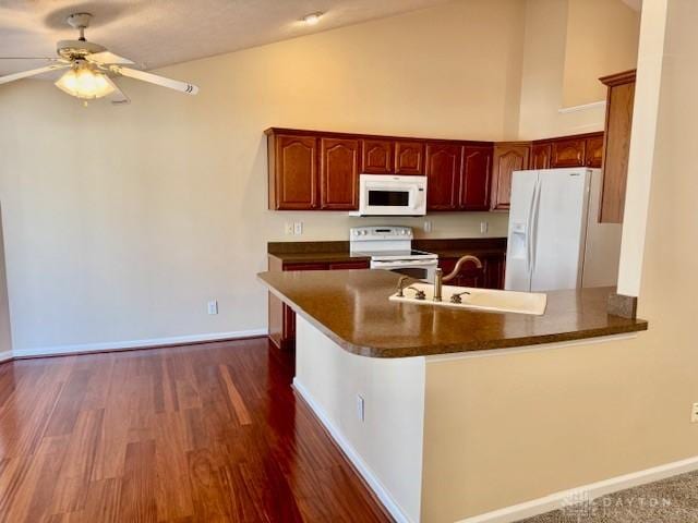 kitchen with high vaulted ceiling, sink, ceiling fan, kitchen peninsula, and white appliances