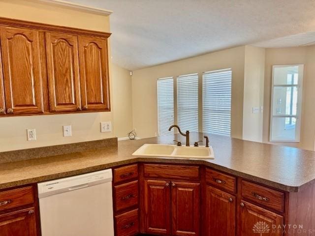 kitchen with white dishwasher, kitchen peninsula, and sink