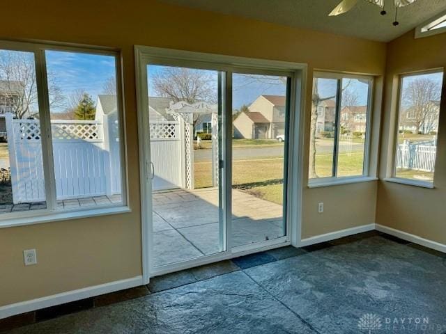 doorway to outside with ceiling fan and vaulted ceiling