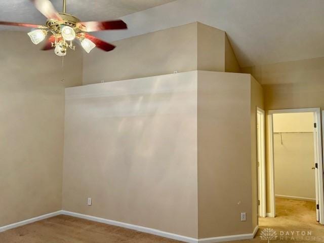 interior space with vaulted ceiling, light colored carpet, and ceiling fan