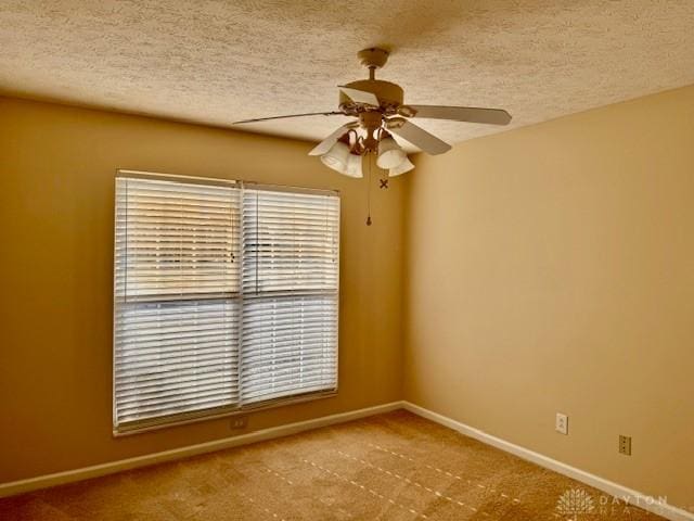 unfurnished room featuring ceiling fan, a textured ceiling, and carpet flooring