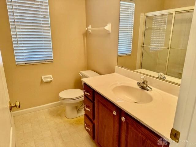 bathroom featuring vanity, walk in shower, and toilet