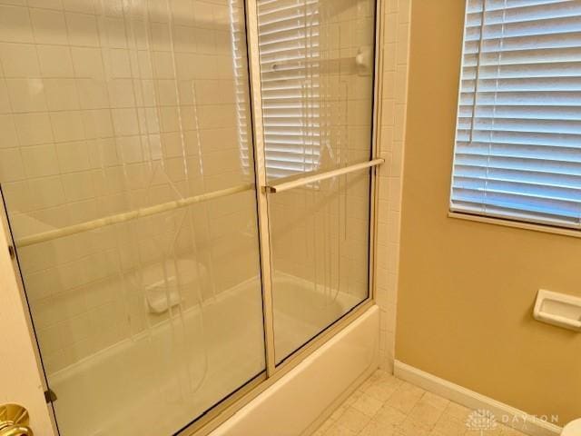 bathroom featuring bath / shower combo with glass door