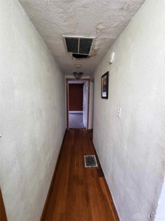 hallway featuring hardwood / wood-style flooring and a textured ceiling