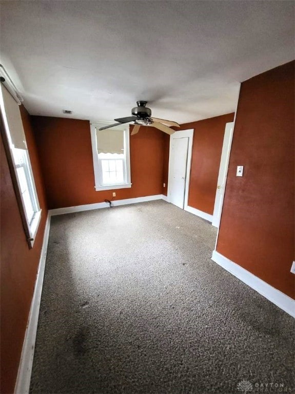 empty room featuring ceiling fan and carpet