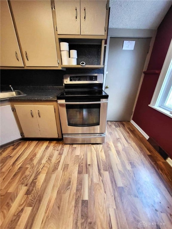 kitchen featuring sink, stainless steel electric stove, a textured ceiling, and light wood-type flooring