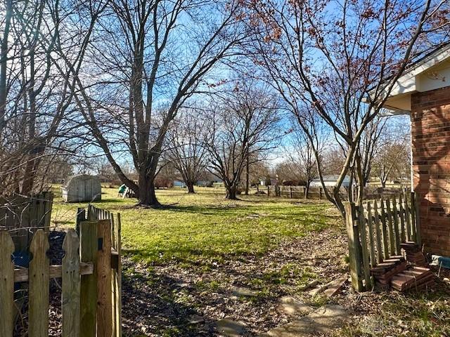 view of yard featuring fence and an outdoor structure