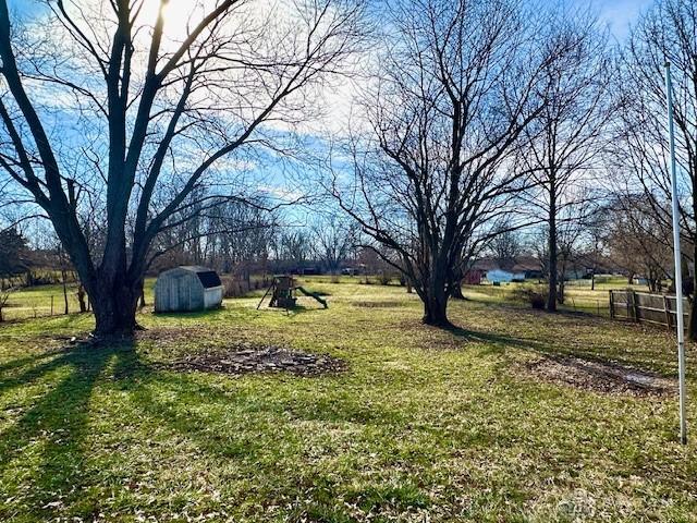 view of yard with an outbuilding, a shed, and fence