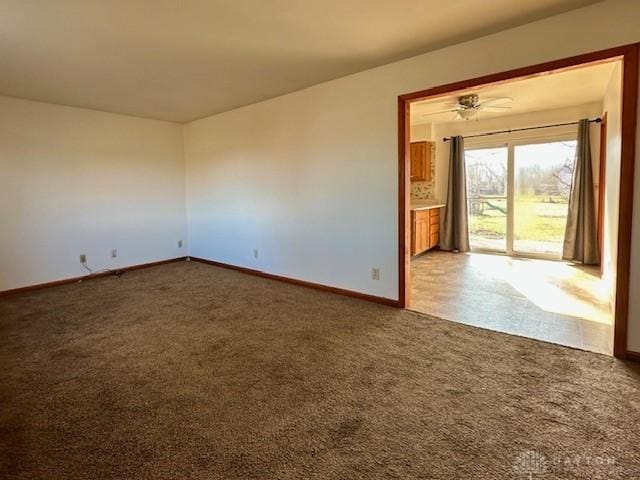 carpeted spare room featuring baseboards