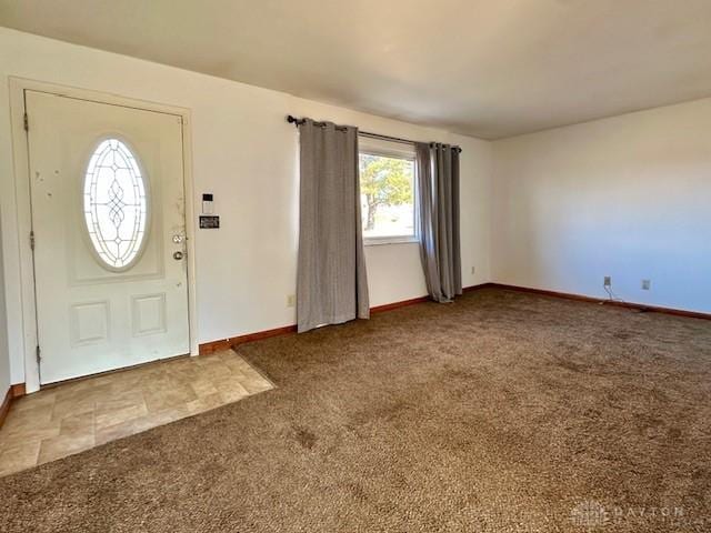 carpeted foyer featuring baseboards