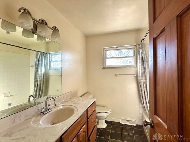 bathroom featuring toilet, plenty of natural light, visible vents, and tile patterned floors