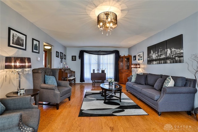 living room with hardwood / wood-style floors and a notable chandelier