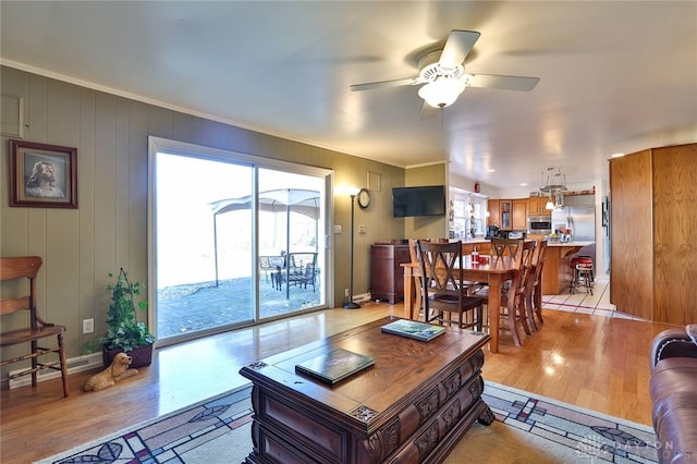 living room featuring ceiling fan, ornamental molding, and light hardwood / wood-style floors