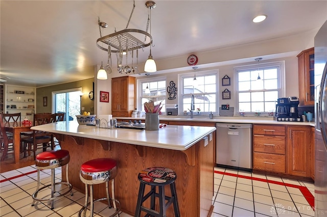 kitchen featuring a breakfast bar area, decorative light fixtures, dishwasher, and a kitchen island