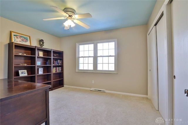 carpeted office space featuring ceiling fan