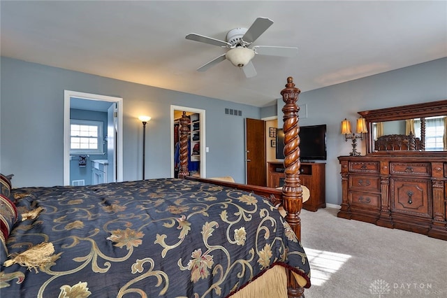 bedroom featuring ceiling fan, a walk in closet, and carpet floors