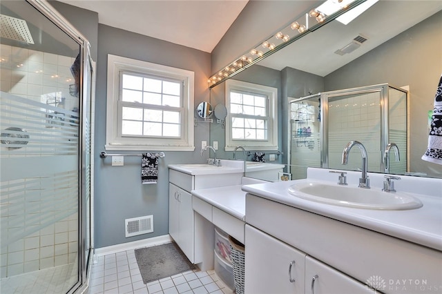 bathroom featuring an enclosed shower, vanity, vaulted ceiling, and tile patterned floors