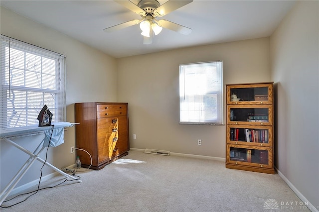 misc room with a healthy amount of sunlight, light carpet, and ceiling fan