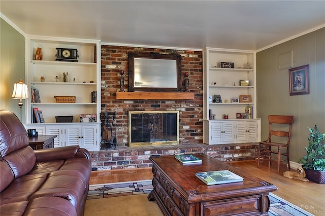 living room featuring hardwood / wood-style flooring, a brick fireplace, and built in shelves