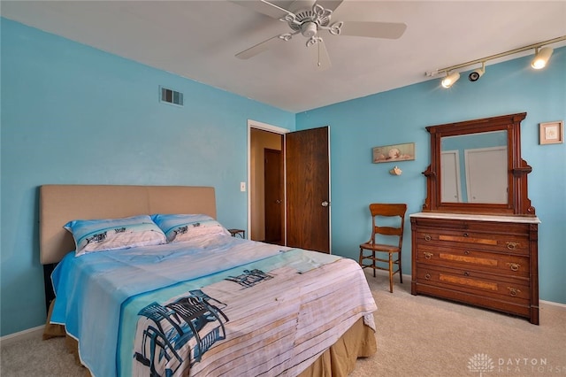 carpeted bedroom featuring rail lighting and ceiling fan