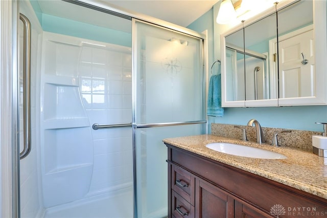 bathroom with vanity and a shower with shower door