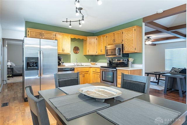 kitchen featuring coffered ceiling, beamed ceiling, hardwood / wood-style flooring, ceiling fan, and stainless steel appliances