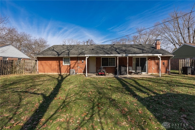 back of property with central AC, a lawn, and a patio area