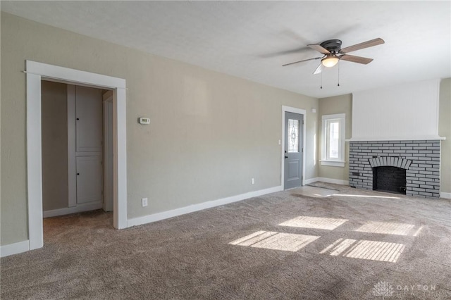 unfurnished living room featuring ceiling fan, carpet flooring, and a brick fireplace