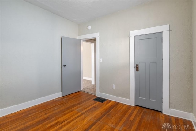 unfurnished bedroom with dark hardwood / wood-style flooring