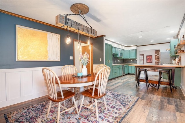 dining room with sink, dark wood-type flooring, and ornamental molding