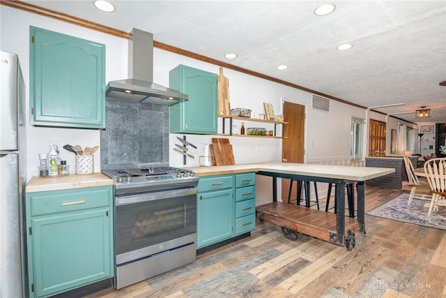 kitchen featuring crown molding, light hardwood / wood-style flooring, stainless steel appliances, and wall chimney exhaust hood