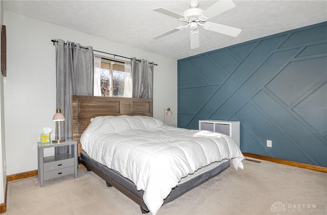 carpeted bedroom with ceiling fan and a textured ceiling