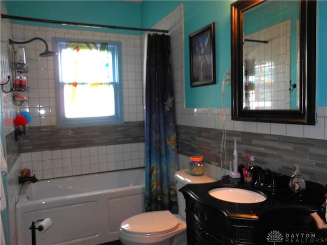 full bathroom with shower / bath combination with curtain, vanity, toilet, and tile walls