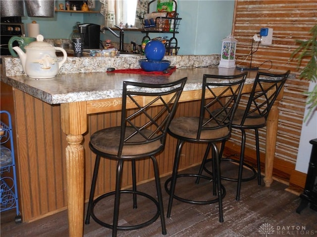 bar featuring sink and dark hardwood / wood-style floors