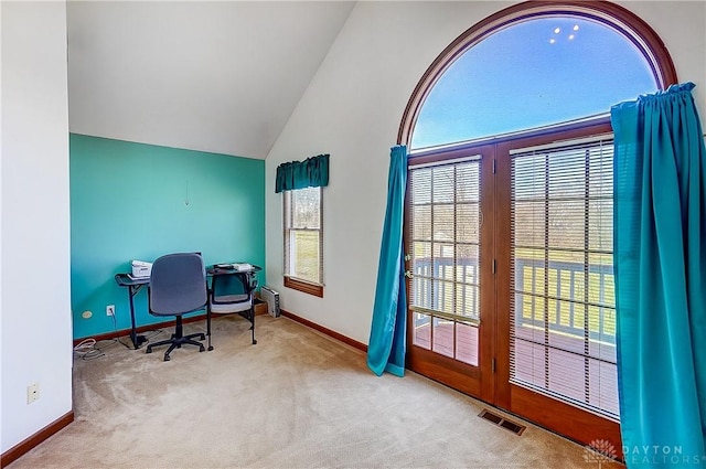 office featuring baseboards, high vaulted ceiling, visible vents, and light colored carpet