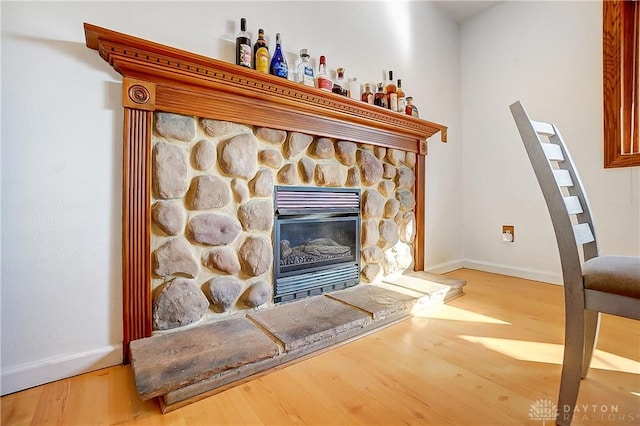 details featuring a fireplace, baseboards, and wood finished floors