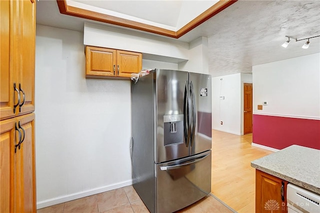 kitchen featuring brown cabinetry, light countertops, white dishwasher, and stainless steel refrigerator with ice dispenser